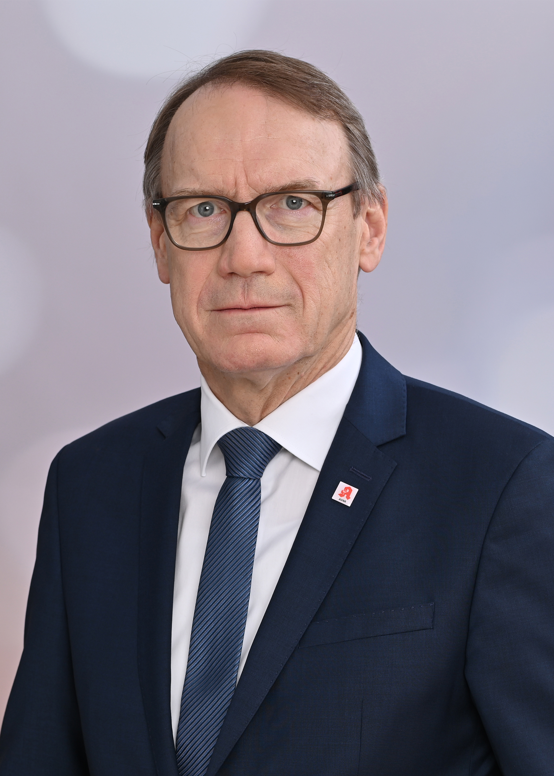 Portraitfoto des ABDA‑Präsidenten Thomas Preis in dunklem Anzug, weißem Hemd und Krawatte, vor neutralem Hintergrund